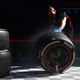 A Red Bull F1 mechanic cleans down a set of wheels.